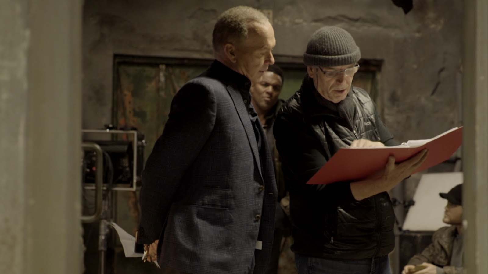 Director Martin Cambell goes over his notes with Michael Keaton. 