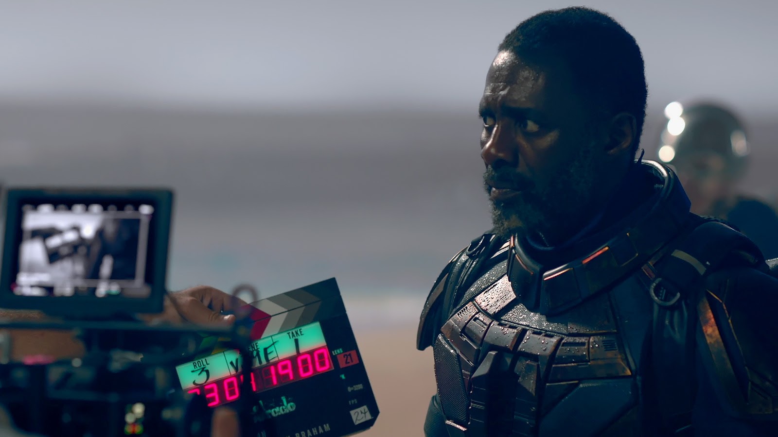 Idris Elba (as Bloodsport) waits for the slate. 