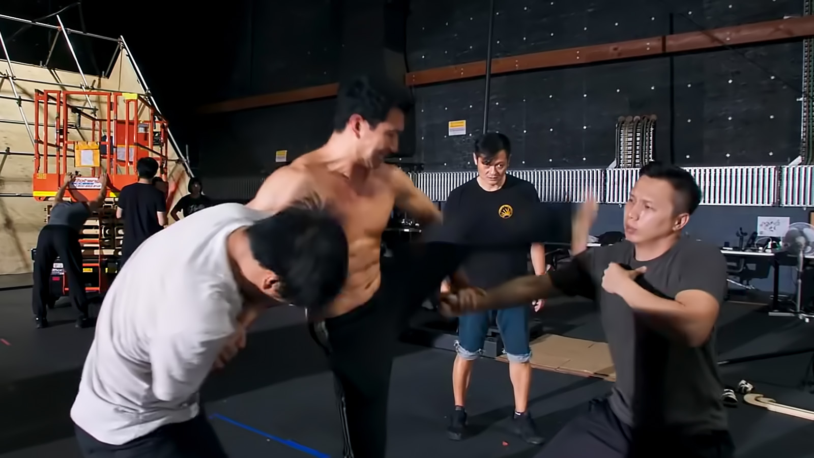 Simu Liu practices his stunt choreography with fight coordinator Andy Cheng in the background.