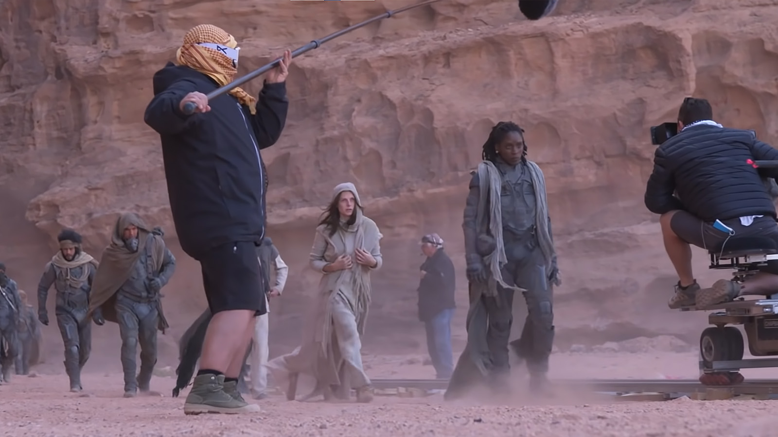 Tracking shot of the Fremen and Lady Jessica following Liet Kynes across the sand. Image © Warner Bros.