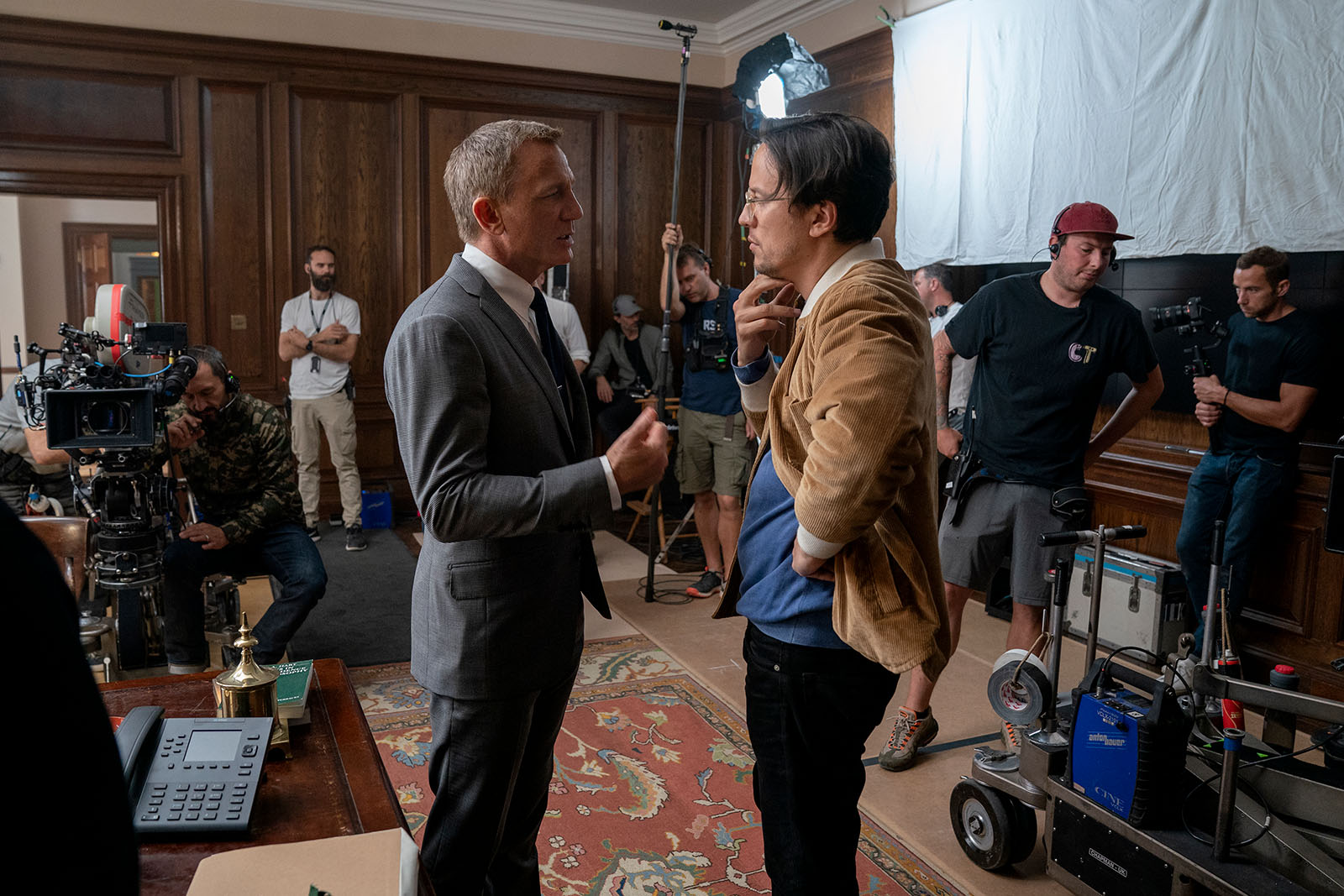 Daniel Craig and Cary Joji Fukanaga confer on the set of No Time to Die.