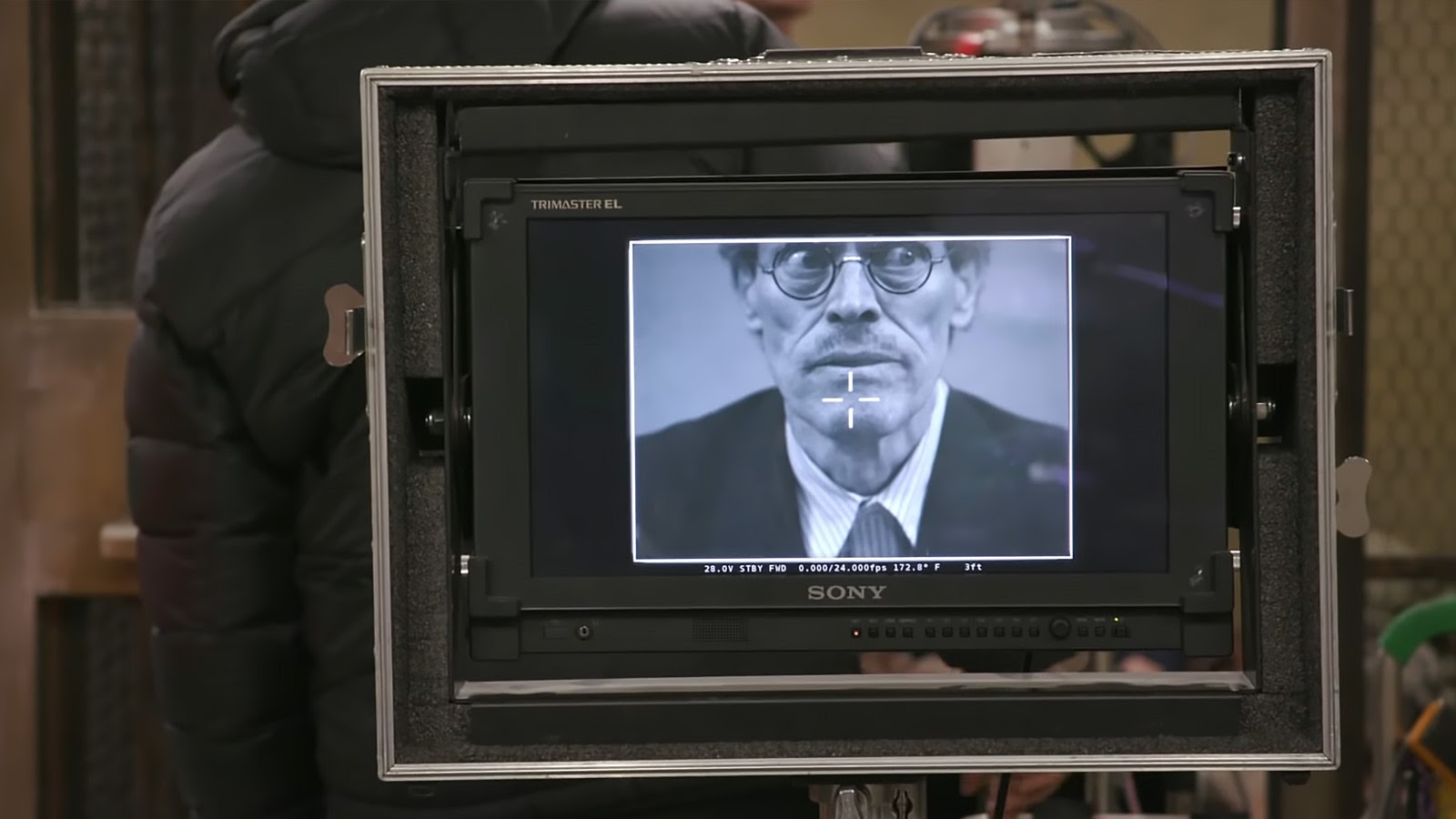 Willem Dafoe as Albert “the Abacus” framed in a monitor on the set for The French Dispatch. Image © Searchlight Pictures