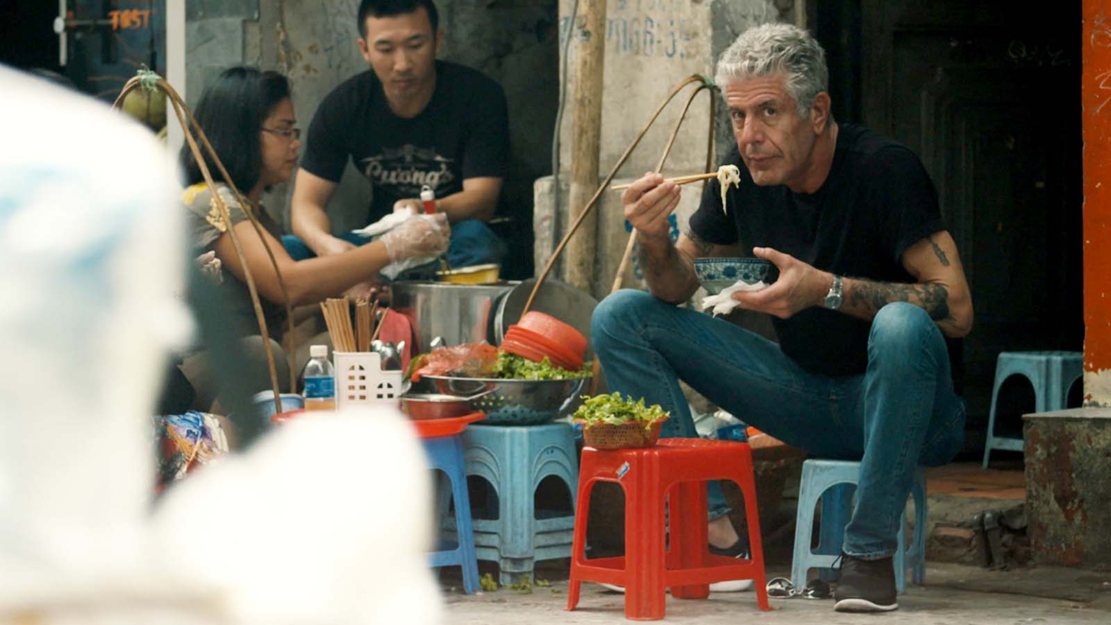 Anthony Bourdain eats street noodles in a scene from Roadrunner. Image © Focus Features