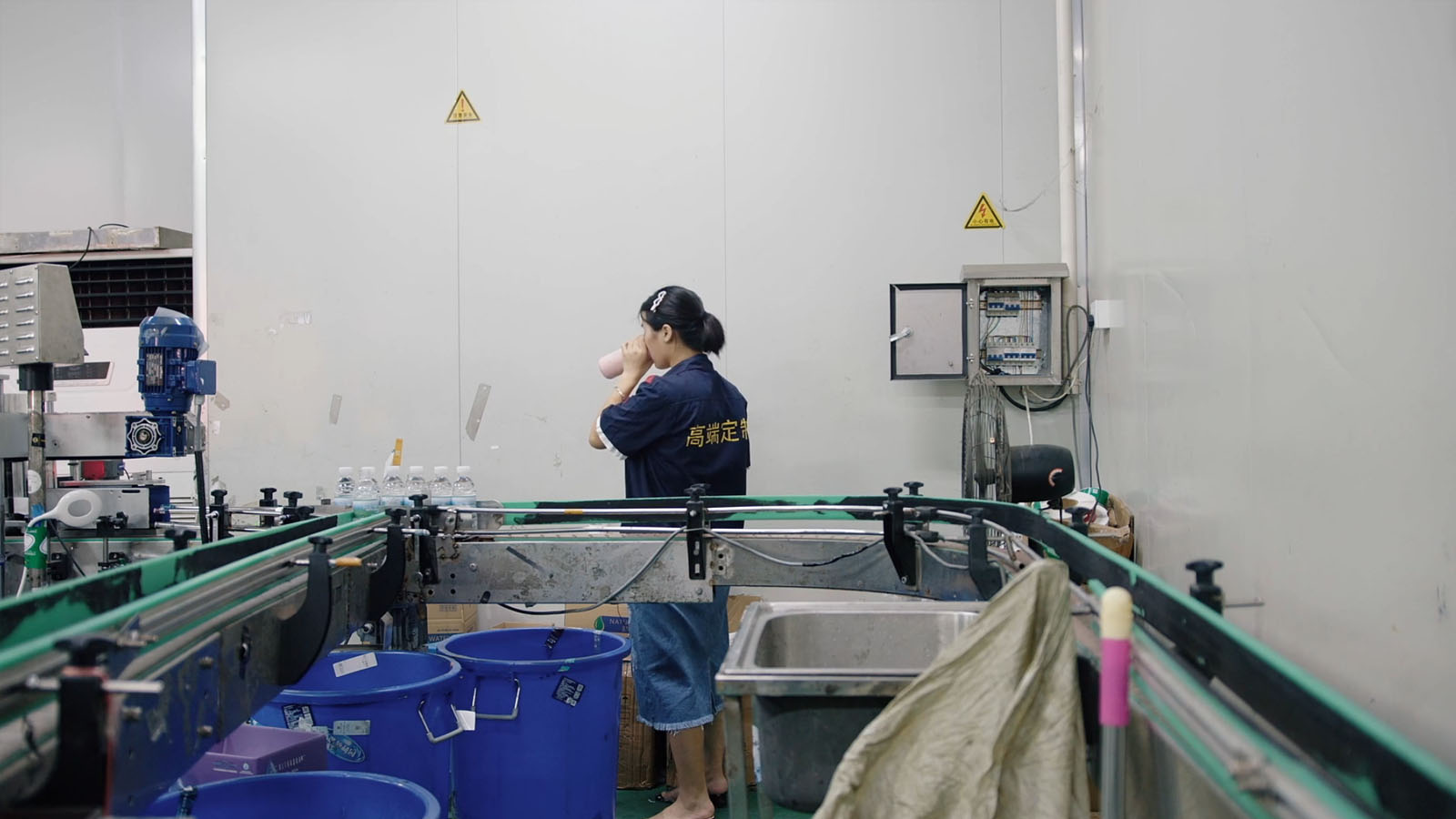 Worker takes a drink during a shift at a bottling plant. Image © MTV Documentary Films