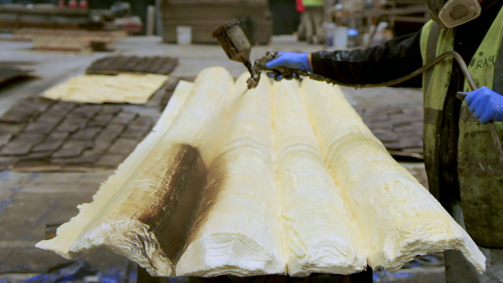 Spray painting foamcore logs for the set of The Northman. Image © Focus Features