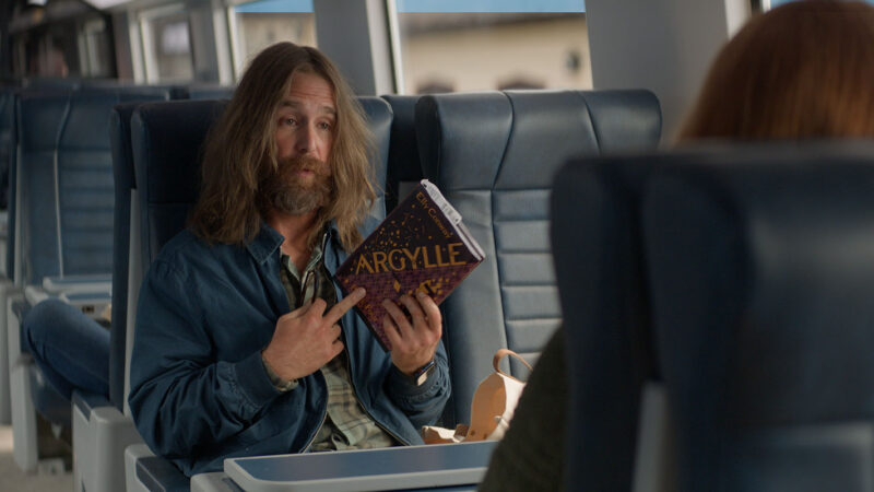 On her way to visit her parents, a mysterious unkempt man sits across from Elly on the train. Image © Apple