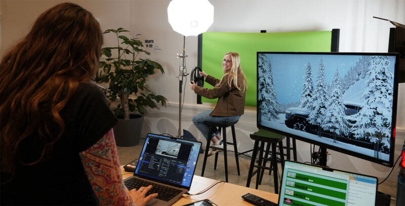 Person sitting in front of green screen with animations.